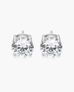 A pair of round-cut solitaire stud earrings in a silver-toned metal setting, displayed on a clean white background.
