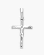 A polished silver crucifix pendant featuring a detailed figure of Jesus Christ on a horizontal arm, set against a plain light gray background.