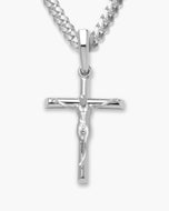 A silver crucifix pendant necklace featuring a detailed figure of Jesus on a polished cross, suspended from a silver curb chain against a light gray background.